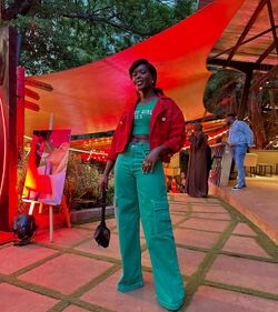 Jacky Vike as Awinja, smiling in colorful attire